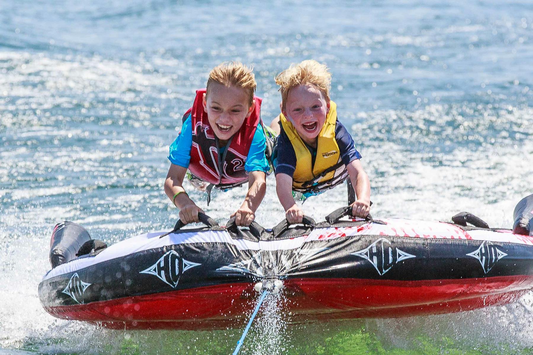 2 kids tubing on a lake