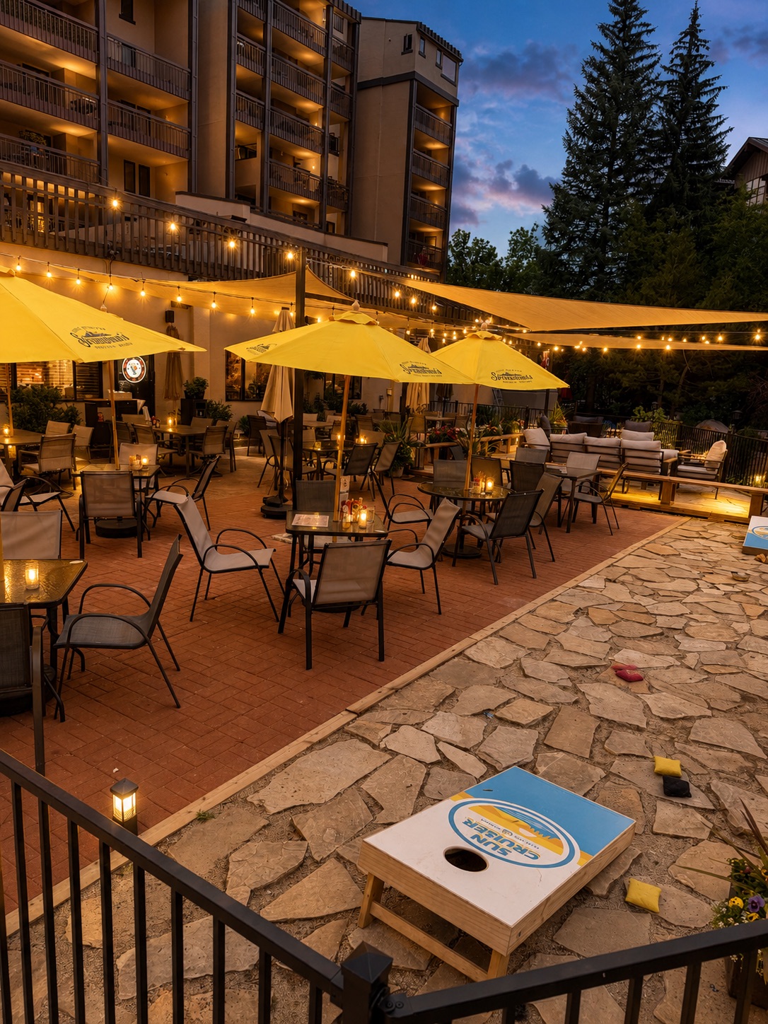 a patio with yellow umbrellas and lights