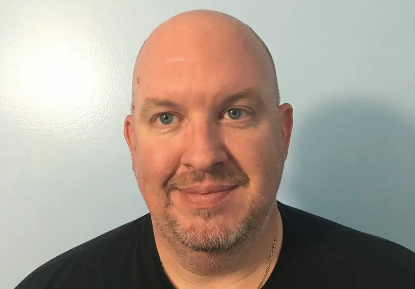 a man who is smiling and looking at the camera