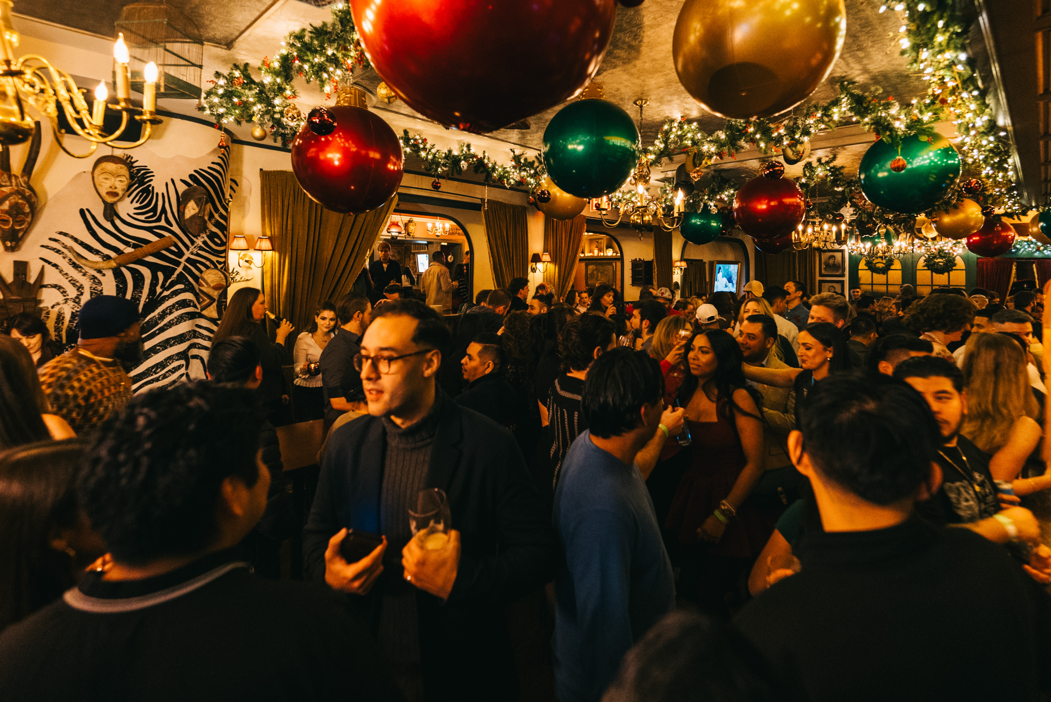 a crowded bar with holiday decor