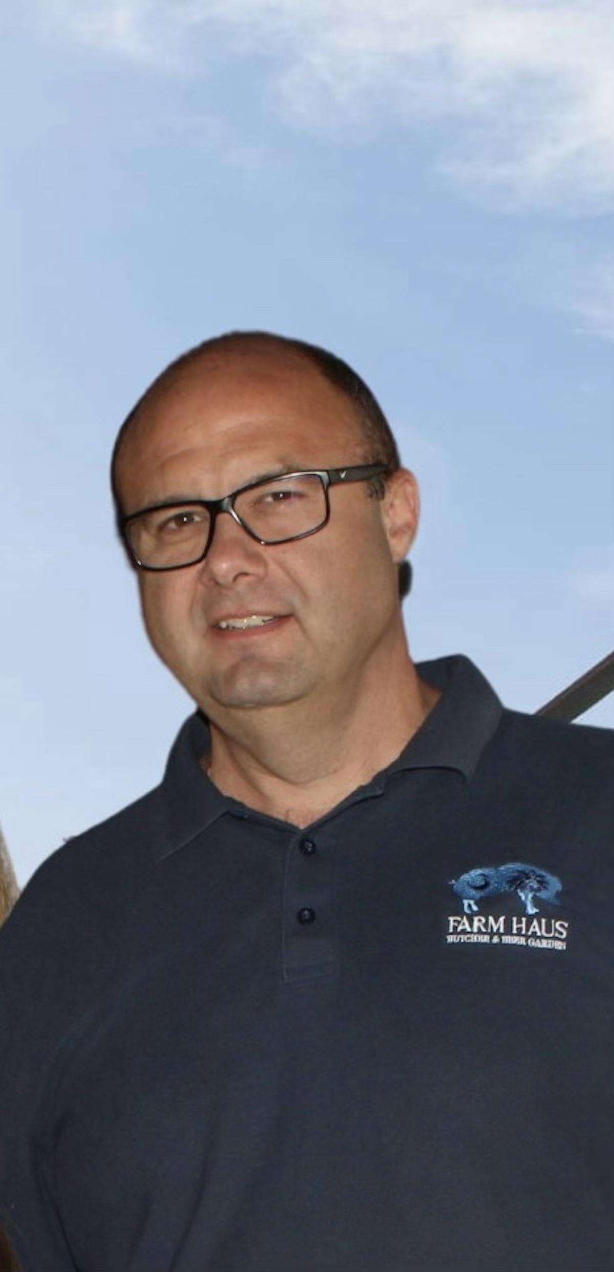 a man wearing glasses and smiling at the camera
