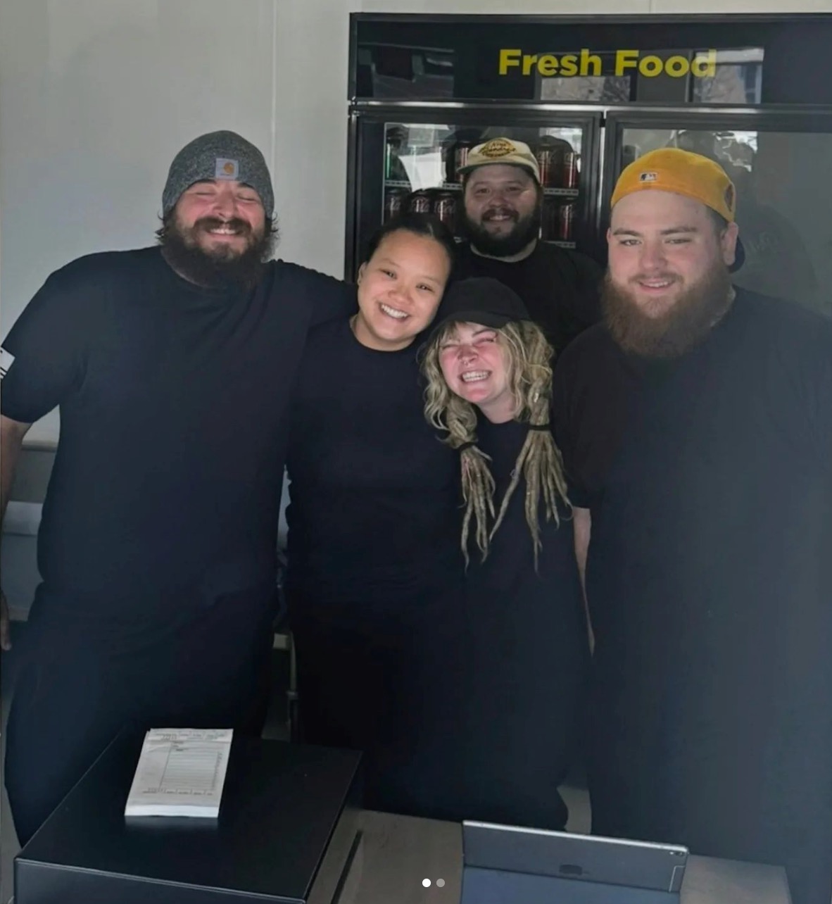 a group of people standing on top of a refrigerator