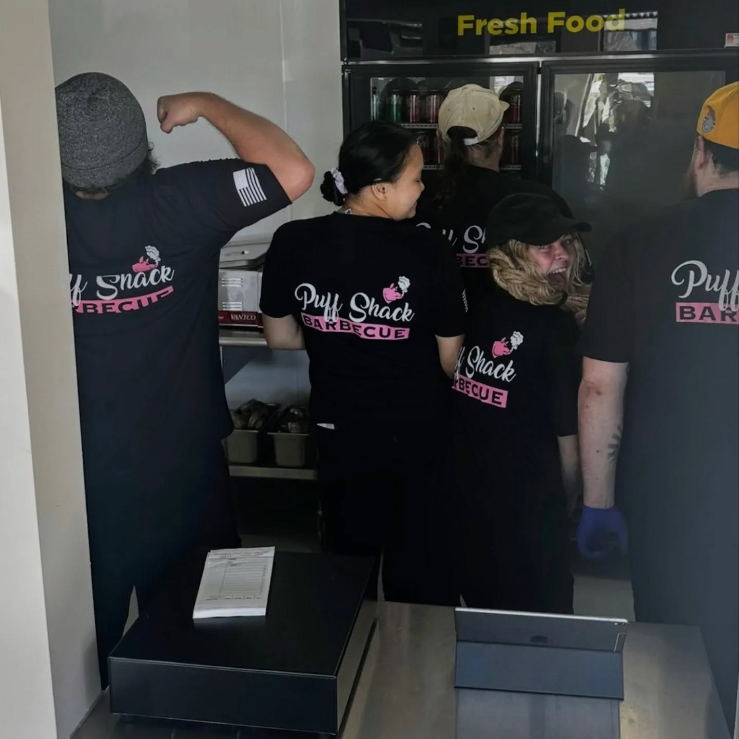 a group of people standing on top of a refrigerator