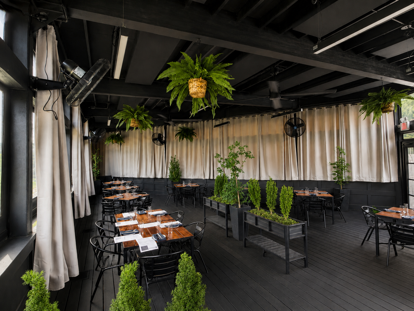 a room with tables and chairs and plants