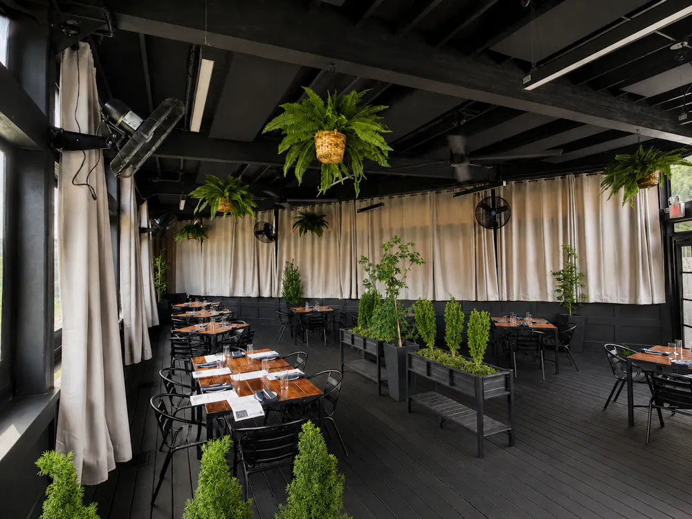 a room with tables and chairs and plants