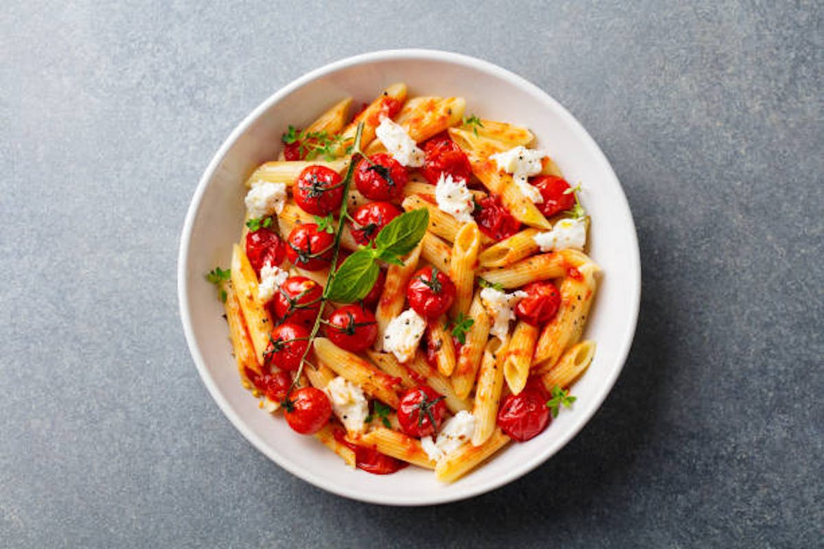 a bowl of penne with butternut squash, prosciutto and cherry tomato sauce