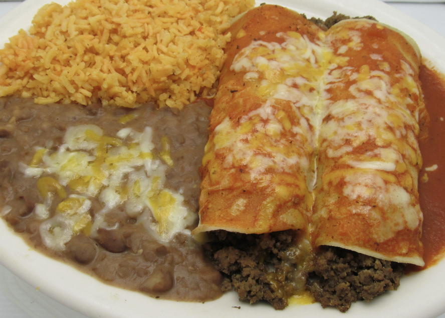a close up of enchiladas with refried beans and rice
