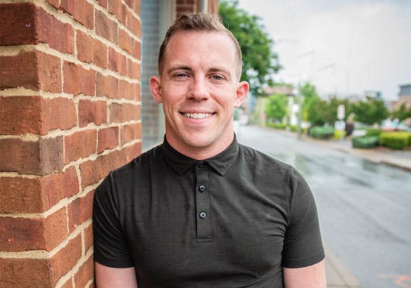 a man standing in front of a brick building