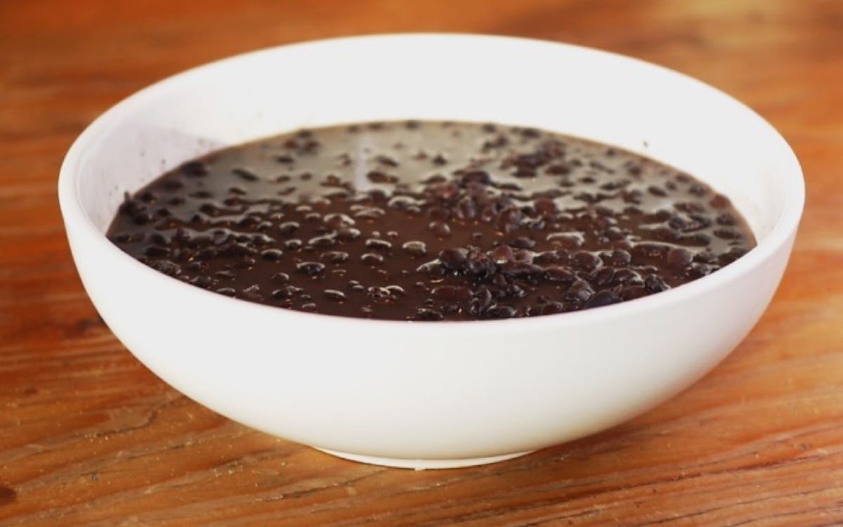 a close up of a bowl of food on a wooden surface