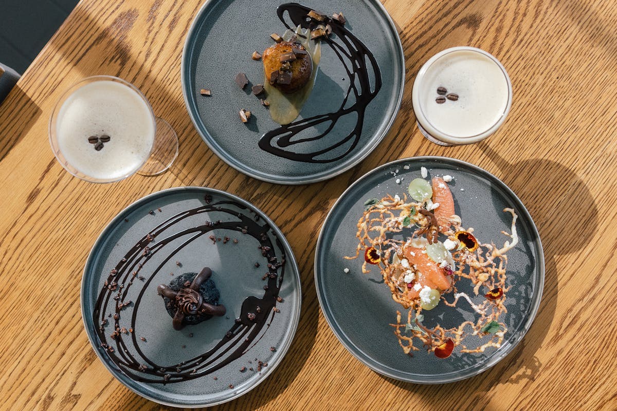 a wooden table topped with plates of food on a plate