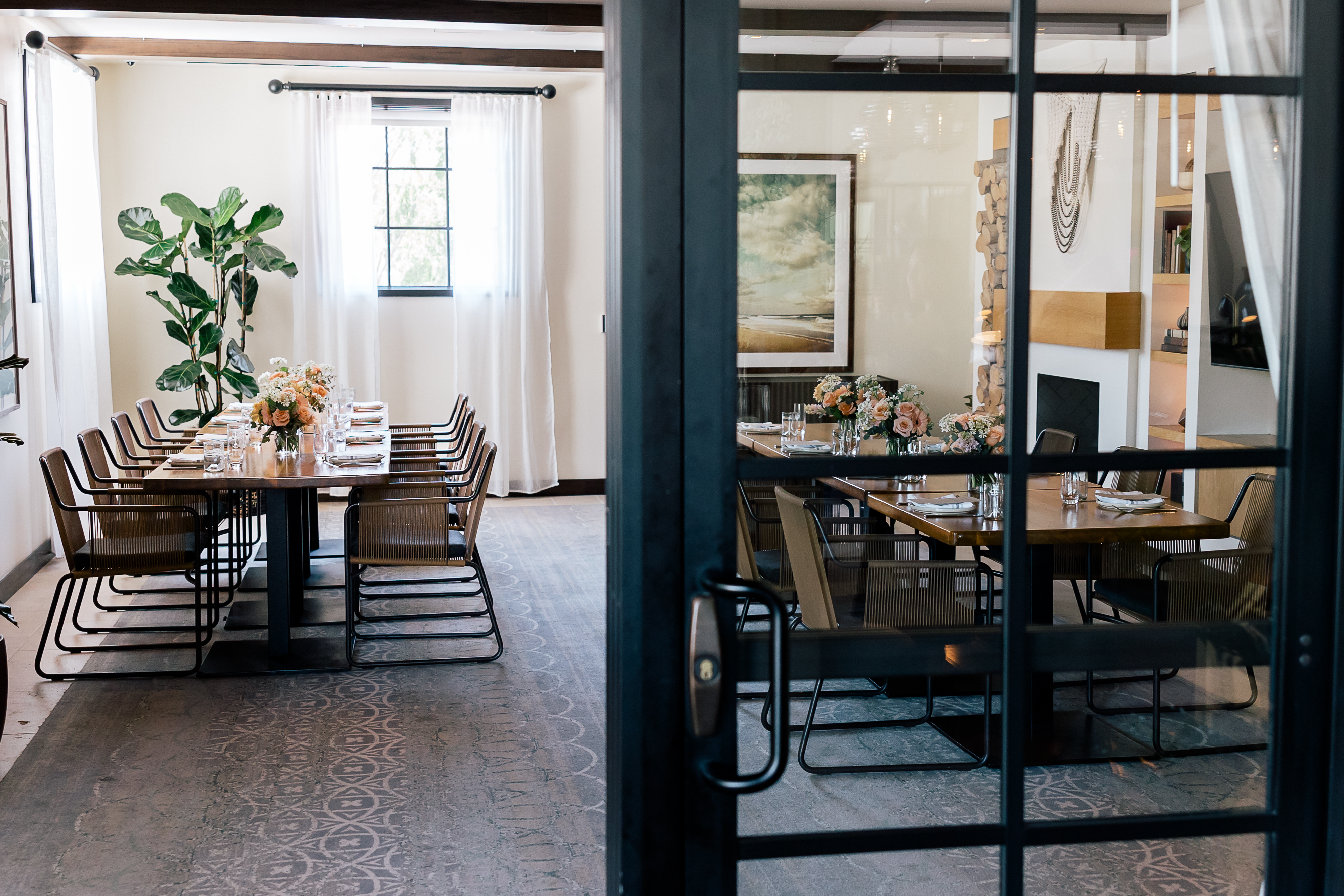 a long table with chairs and a plant in front of it