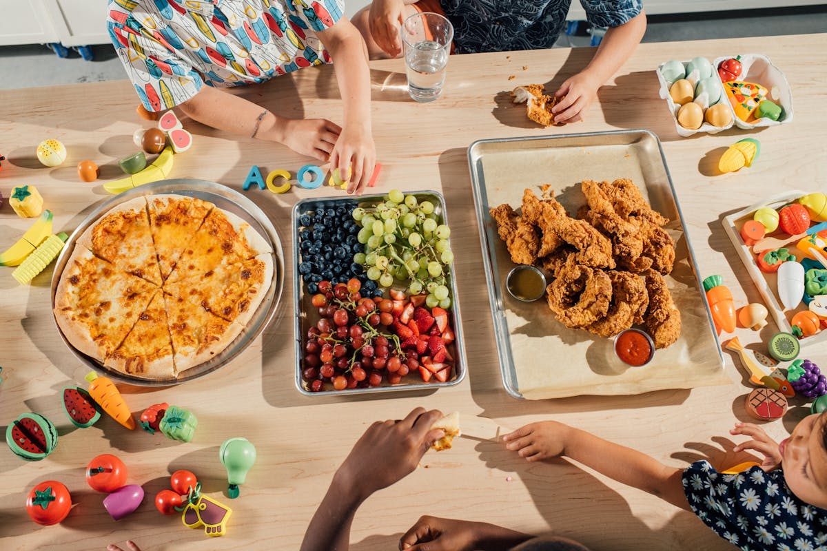 a person holding a bunch of food on a table
