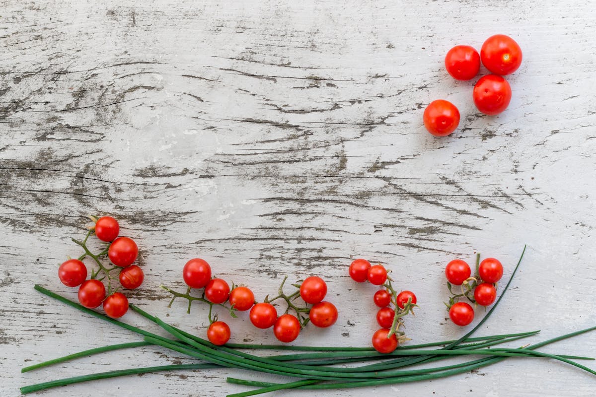 a close up of red berries lying on a wooden table