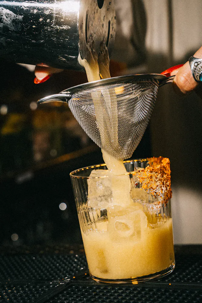 a person pouring liquid into a glass
