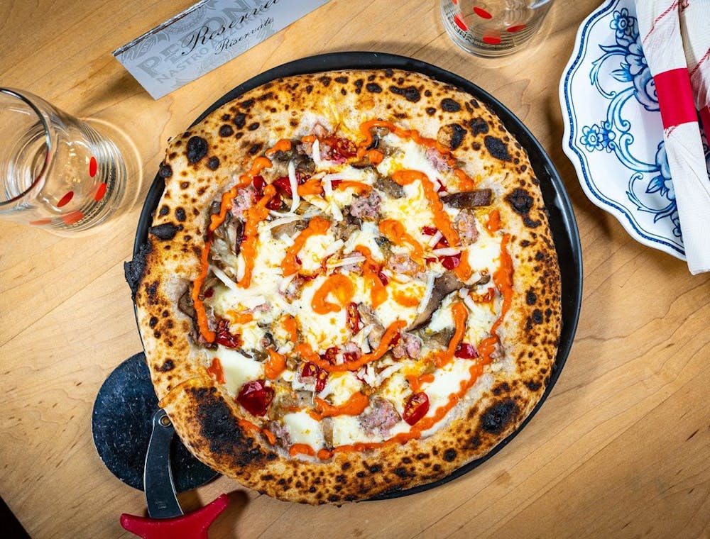a pizza sitting on top of a wooden table