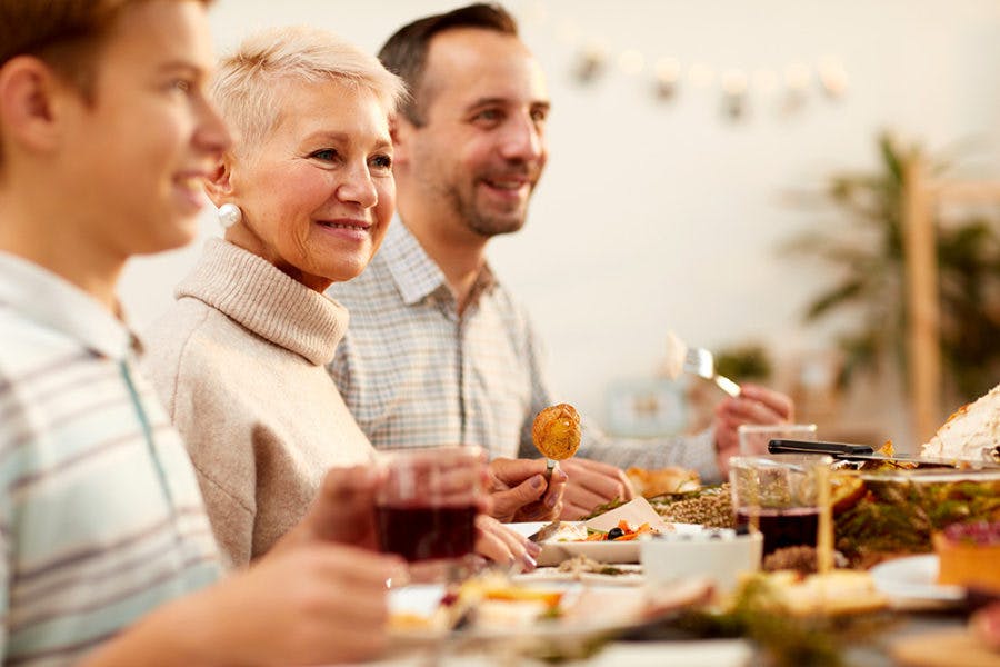 a group of people sitting at a table with food