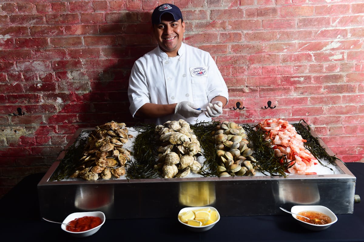 a man standing in front of a tray of food