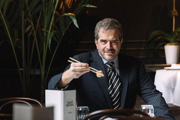 a man wearing a suit and tie sitting at a table