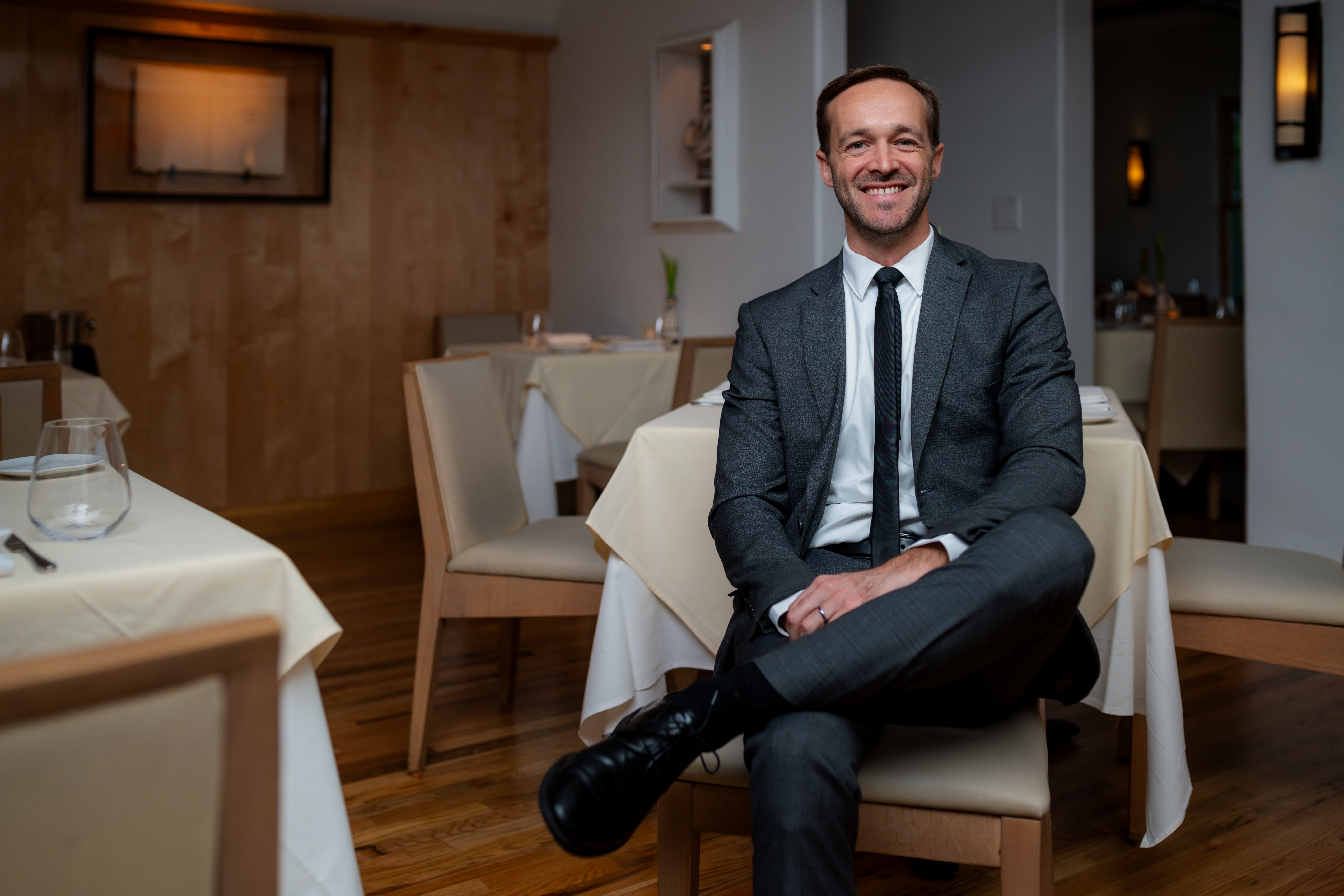 a man wearing a suit and tie sitting in a chair