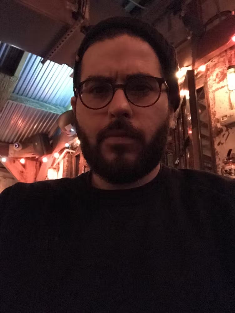 a man posing for a photo in glasses