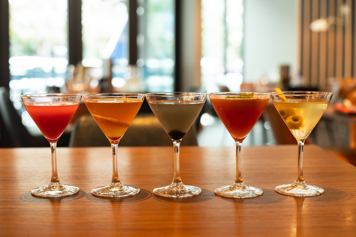 several glasses of wine sitting on top of a wooden table