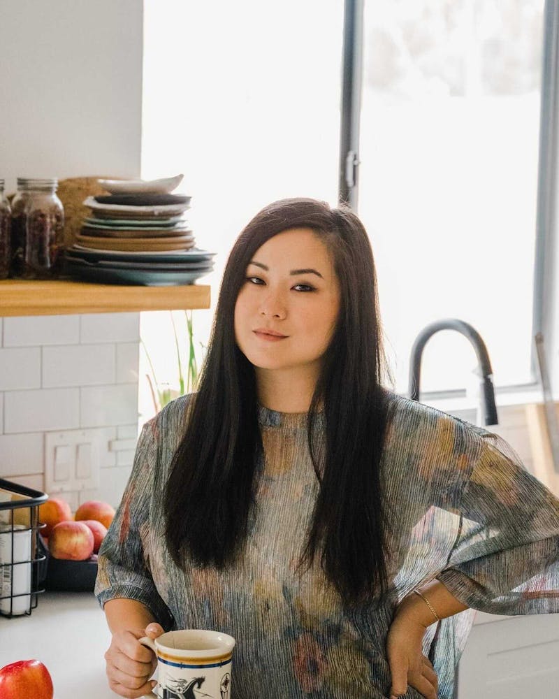 Jenny Gao sitting at a table in front of a window