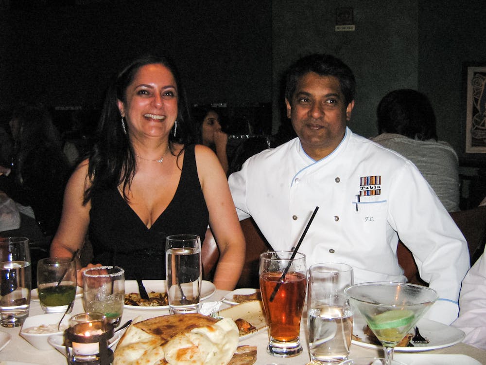 Floyd Cardoz et al. sitting at a table with wine glasses