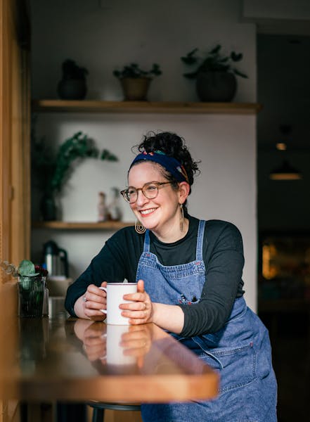 a person holding a glass of beer on a table