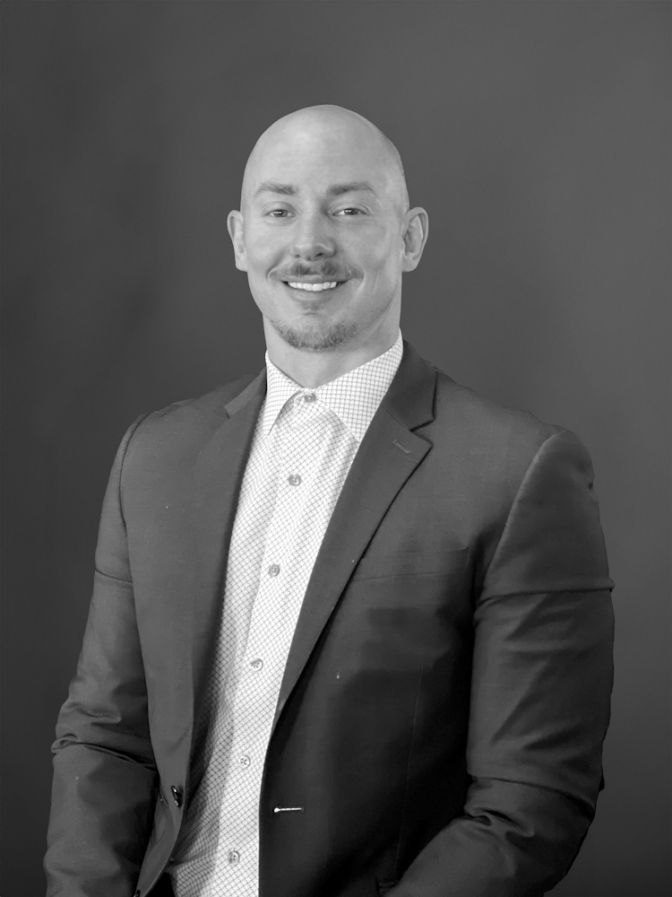 a man wearing a suit and tie smiling at the camera