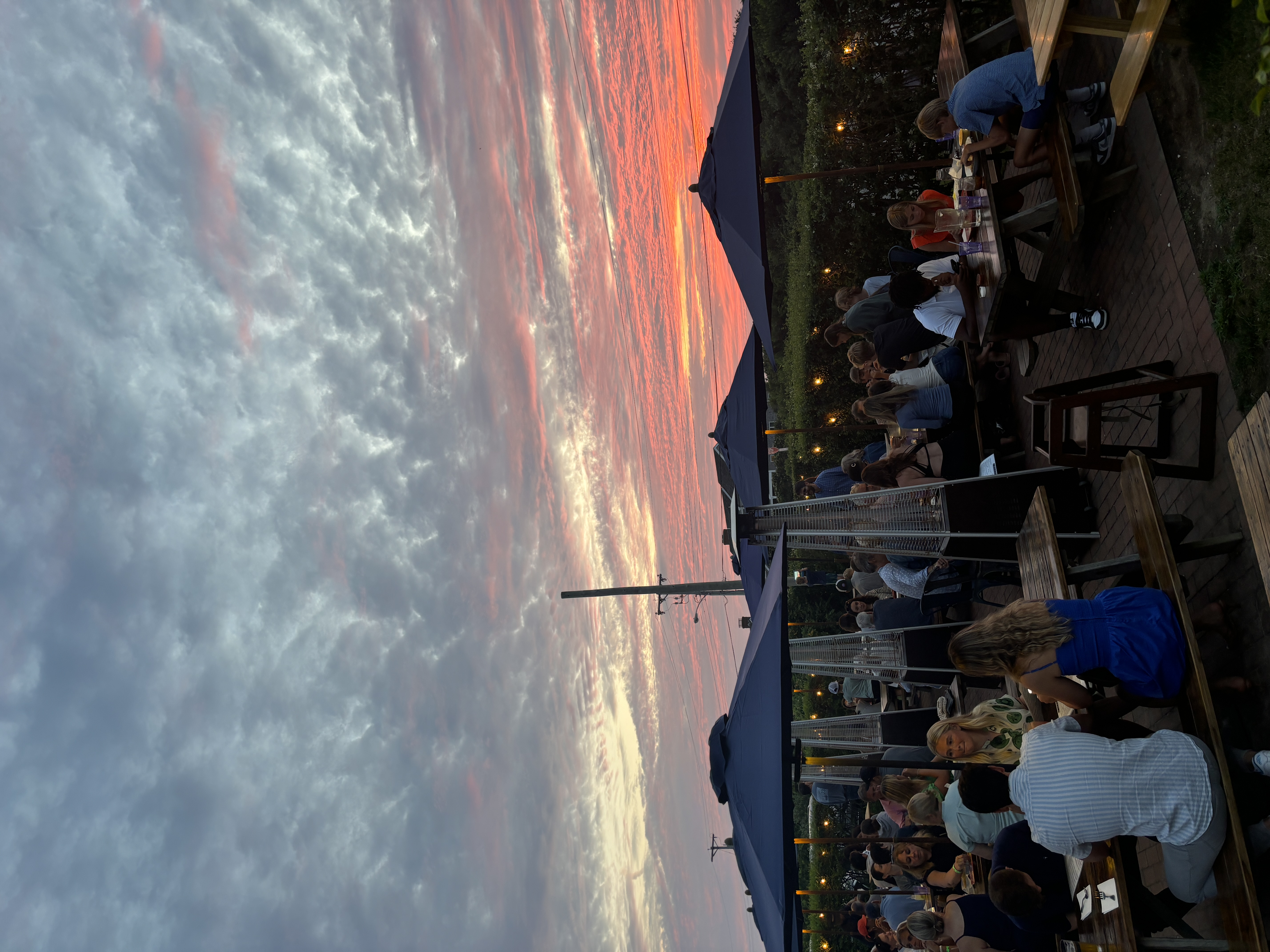 a group of people sitting at a table with a mountain in the background
