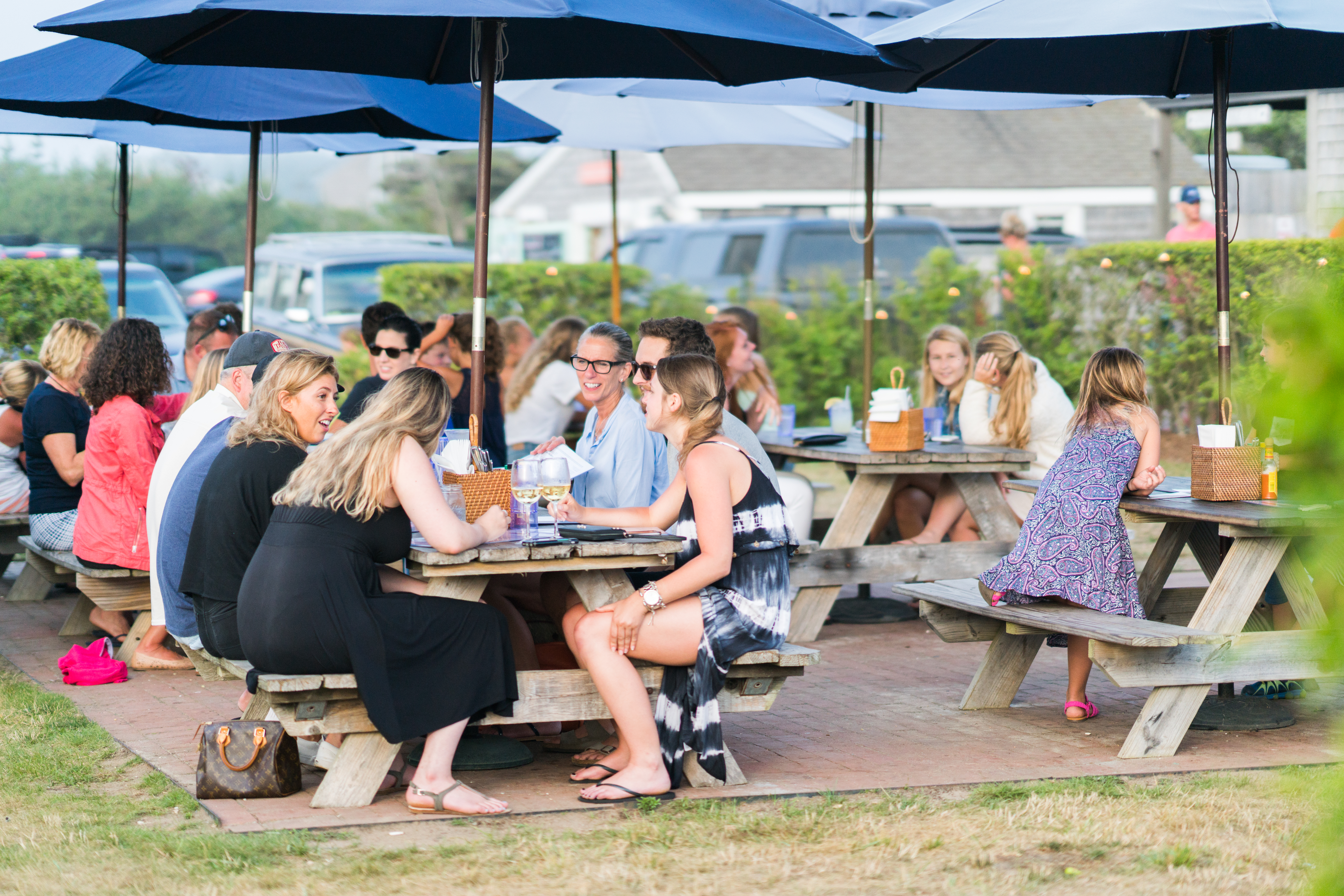 a group of people sitting at a table with an umbrella