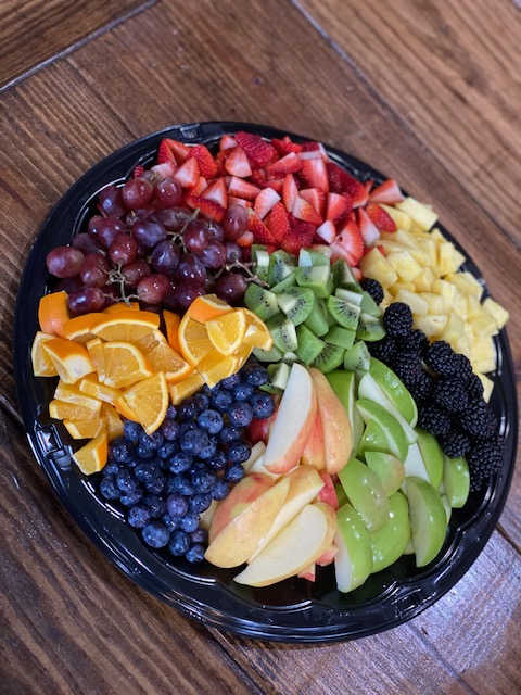 a bowl of fruit sitting on top of a wooden table