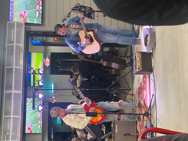 a group of people playing instruments and performing on a stage