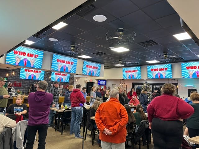 a group of people waiting for their luggage at an airport