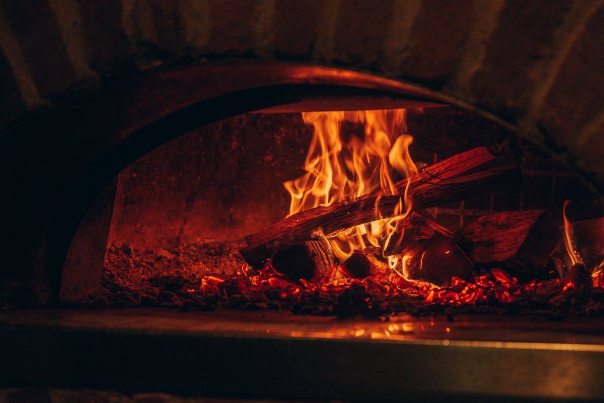 a pizza sitting on top of a fire oven