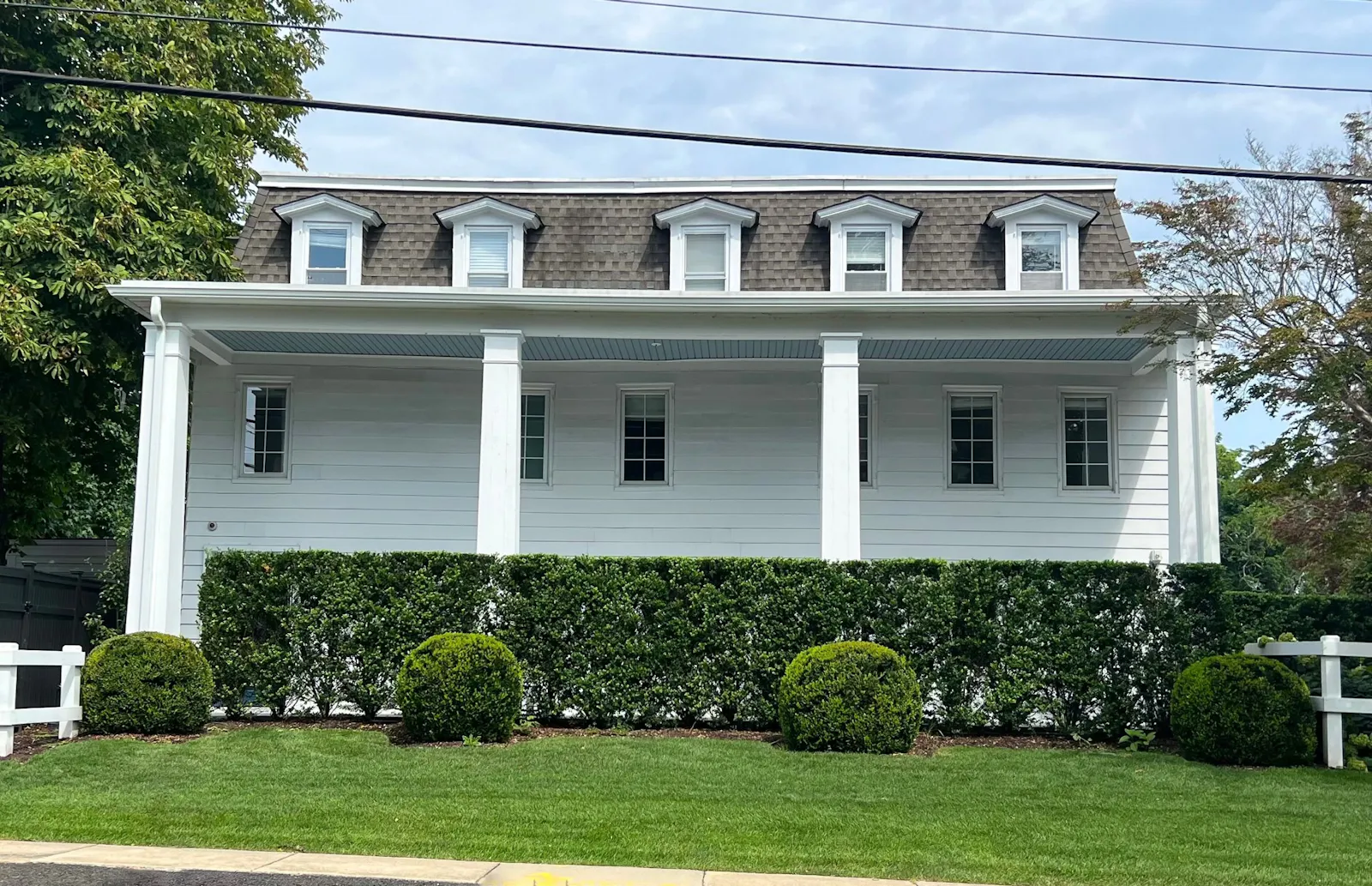 The inn's mansard roof and front porch from Main Road