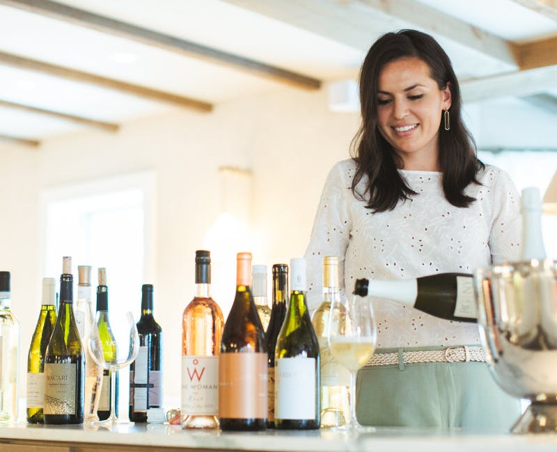 a woman holding a bottle of wine