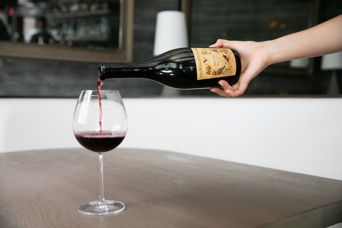 a hand holding a glass of wine