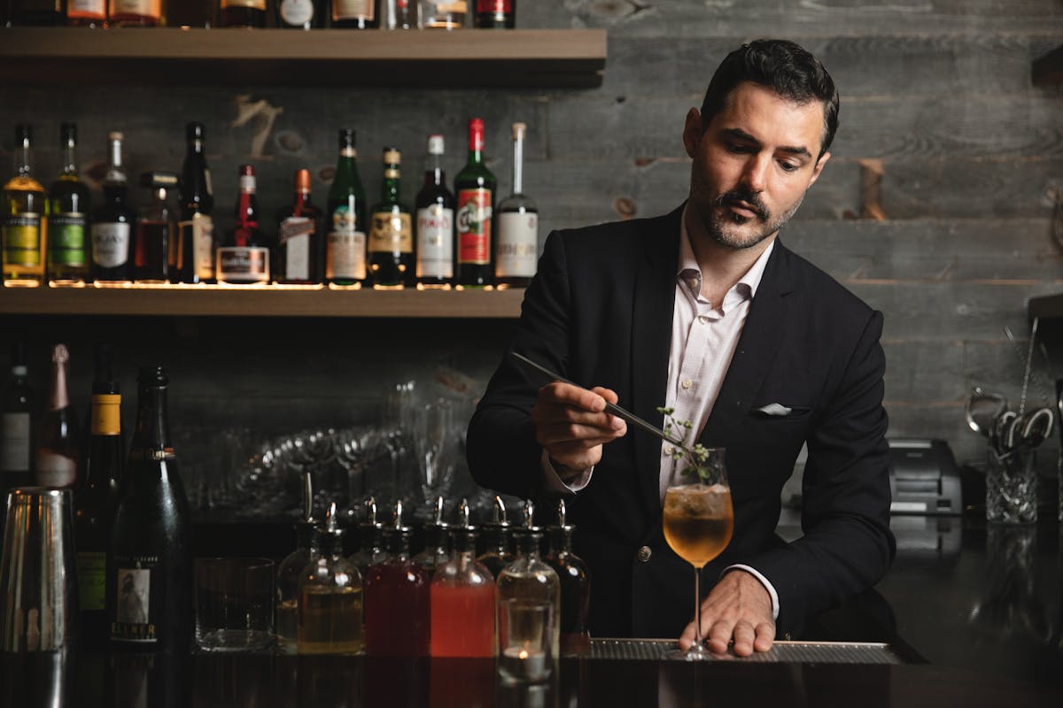 a man holding a beer bottle and a glass of wine