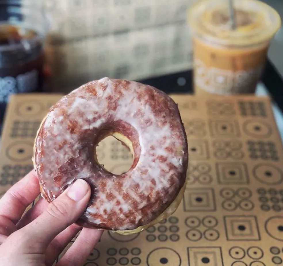 a close up of a hand holding a donut