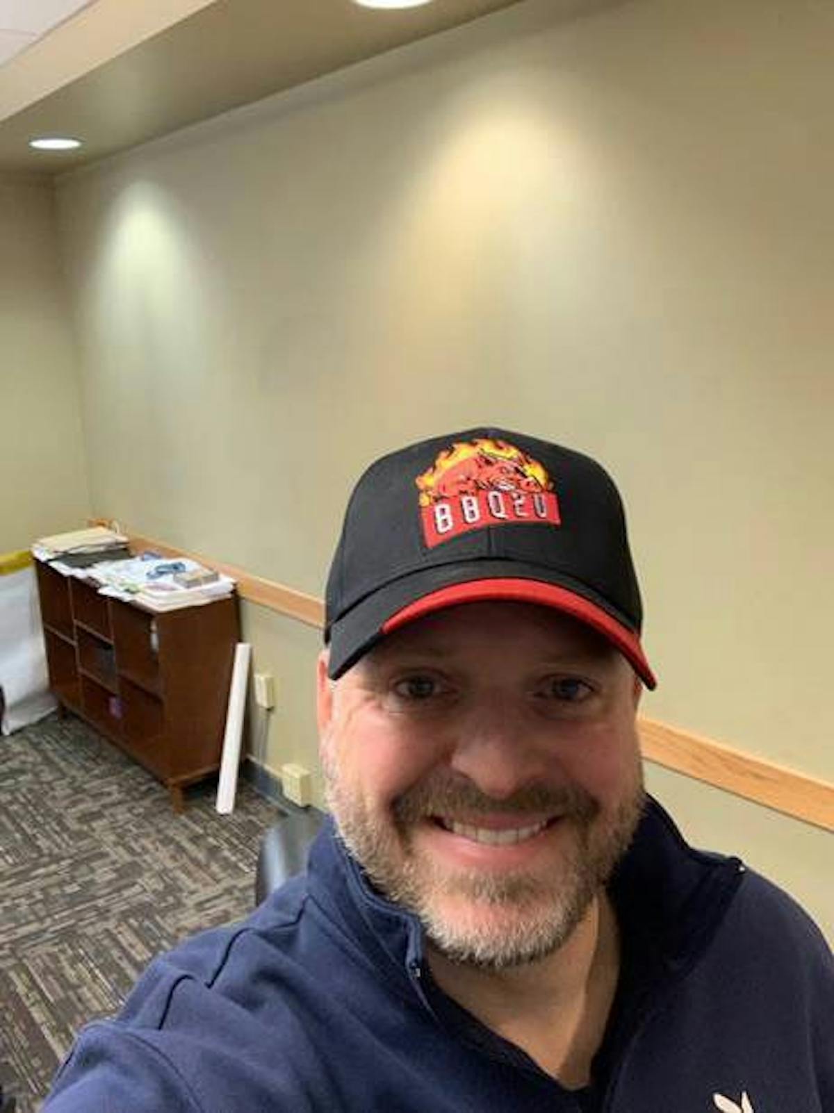 a man wearing a hat and smiling at the camera