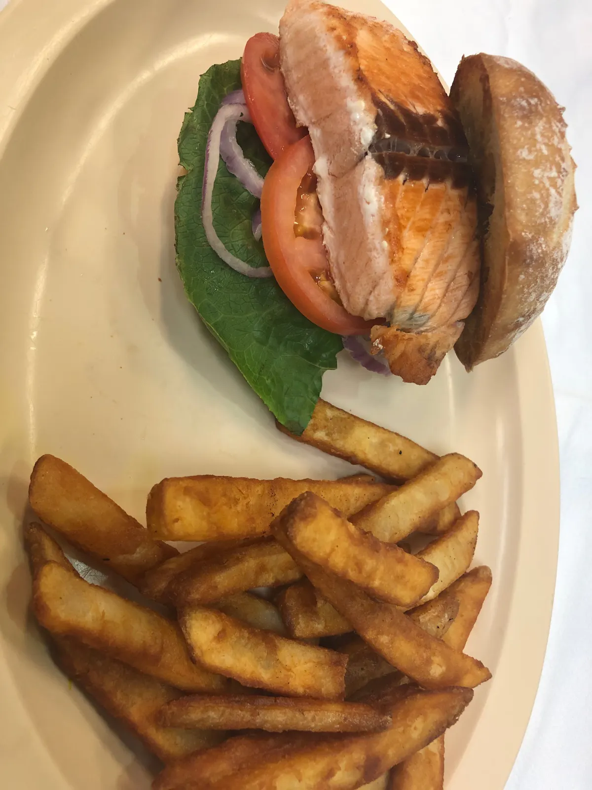 a salmon san dwich fries on a plate
