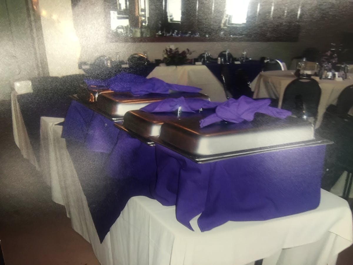 a room filled with a table topped with purple table cloth