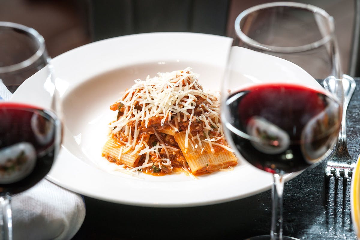 a close up of a plate of food and a glass of wine