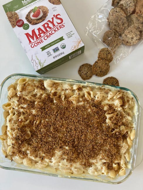 a box of crackers next to a casserole dish of mac and cheese