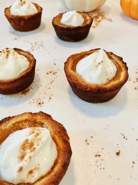 5 mini pumpkin pies on a white plate