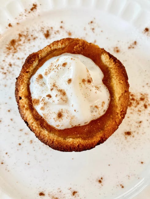 a mini pumpkin pie with whipped cream on top