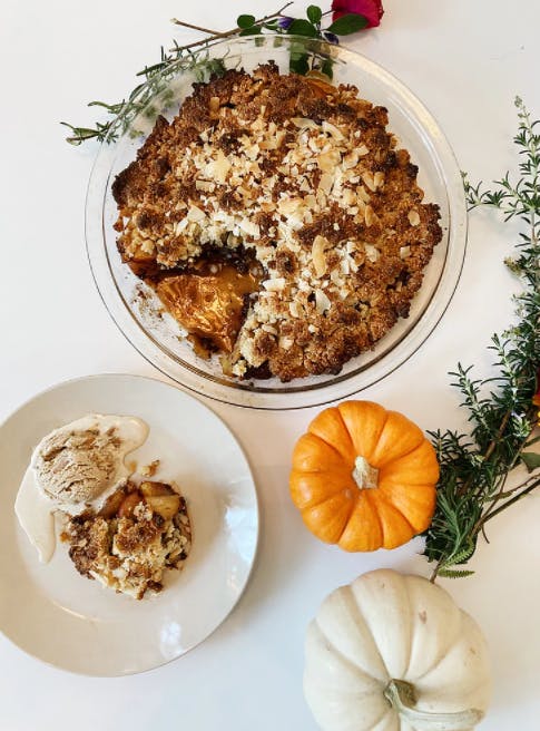 dark chocolate crumble next to a plate with a serving on it next to mini pumpkins