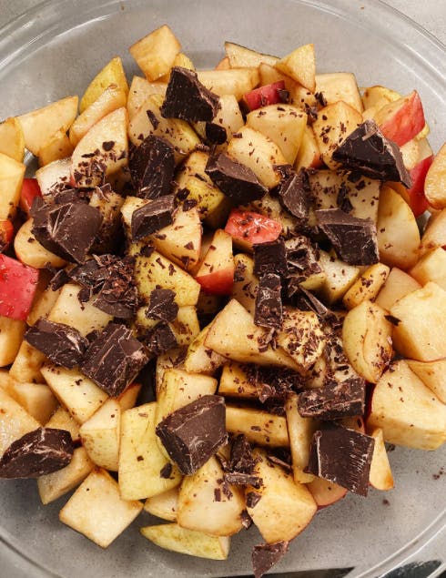 a bowl of apples and chocolate chunks