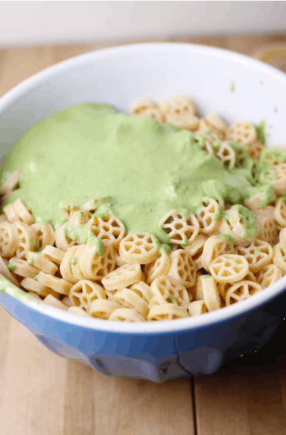 a bowl of pasta with pesto poured over it